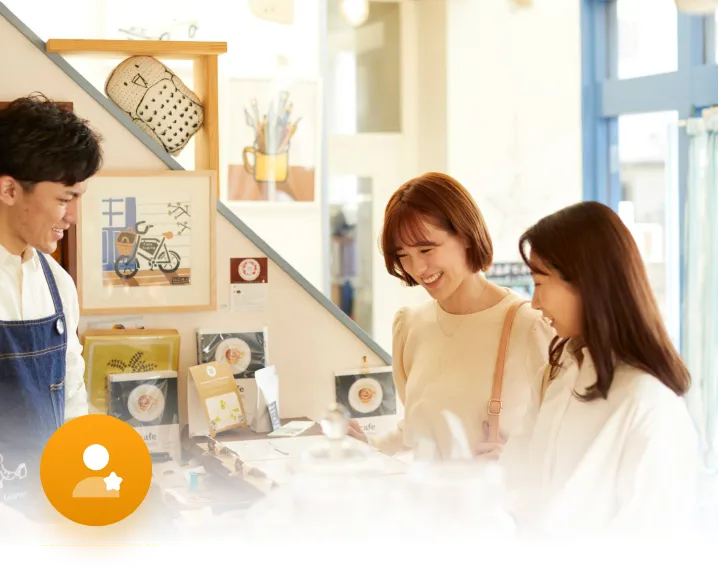 Retail staff engaging customers at a store counter, representing a customer loyalty rewards programme
